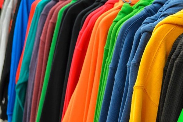 Lote de sudaderas de distintos colores colgadas en perchas, la imagen se utiliza para explicar como añadir un lote en ropa mayor